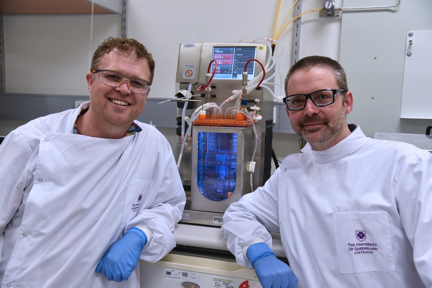 AIBN’s Dr Steve Dingwall and Dr Andrew Prowse in a lab wearing white coats.