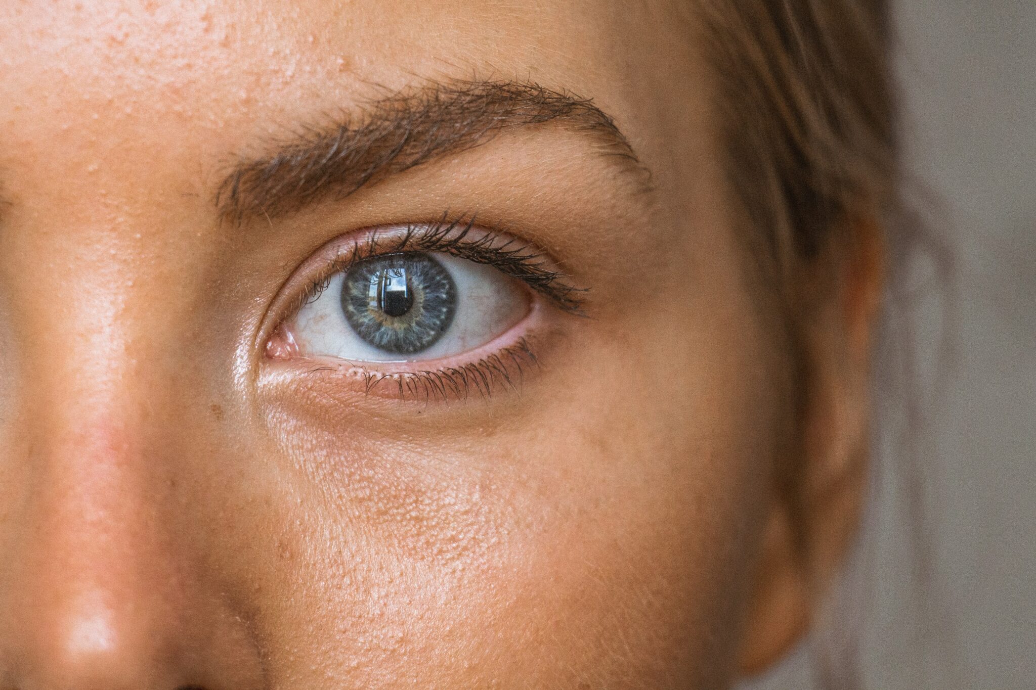 Partial image of female face, showing part of nose, eyebrow, eye and ear