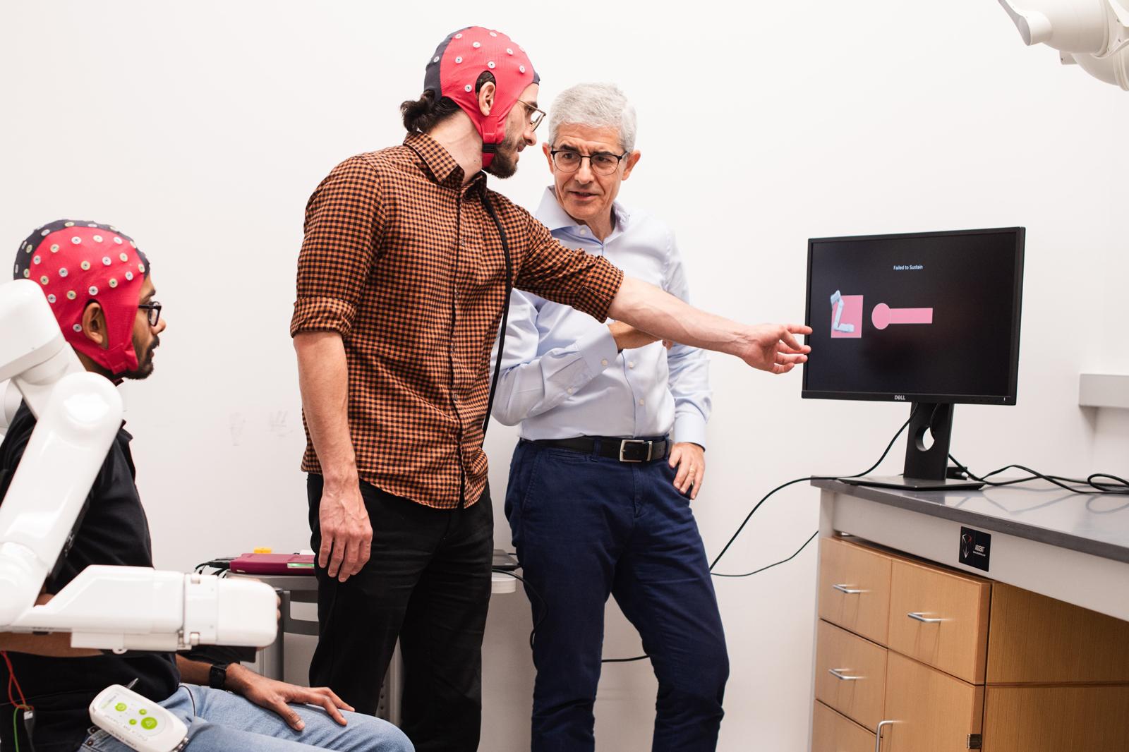Researchers Satyam Kumar, Hussein Alawieh and José del R. Millán show device in action