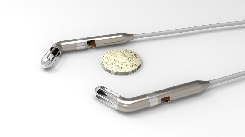 MiniPump device shown with Australian one dollar coin to indicate size.